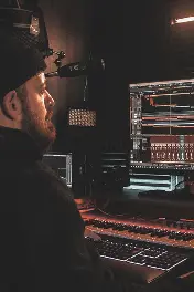 An audio engineer producing a podast show on his computer